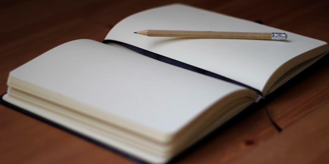 An open journal with a pencil