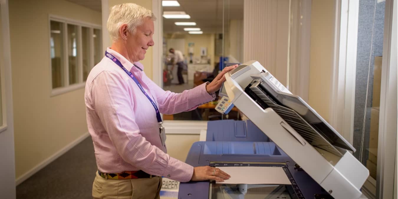 Man using a large copier scanner.