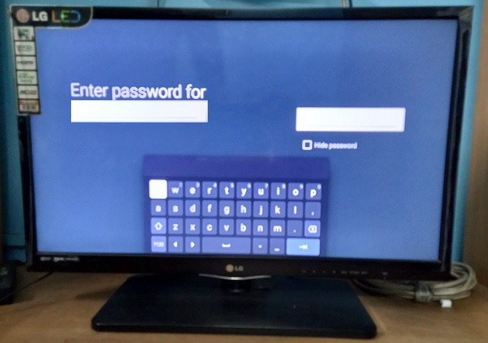Entering a Wi-Fi password for its required fields in a smart TV. 