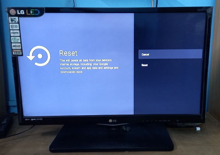 Clicking the "Reset" button on an Android TV. 